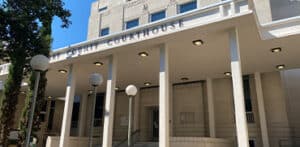 Fachada del Tribunal del Condado de Montgomery, Texas, con columnas y letrero visible, representando el 418th District Court.